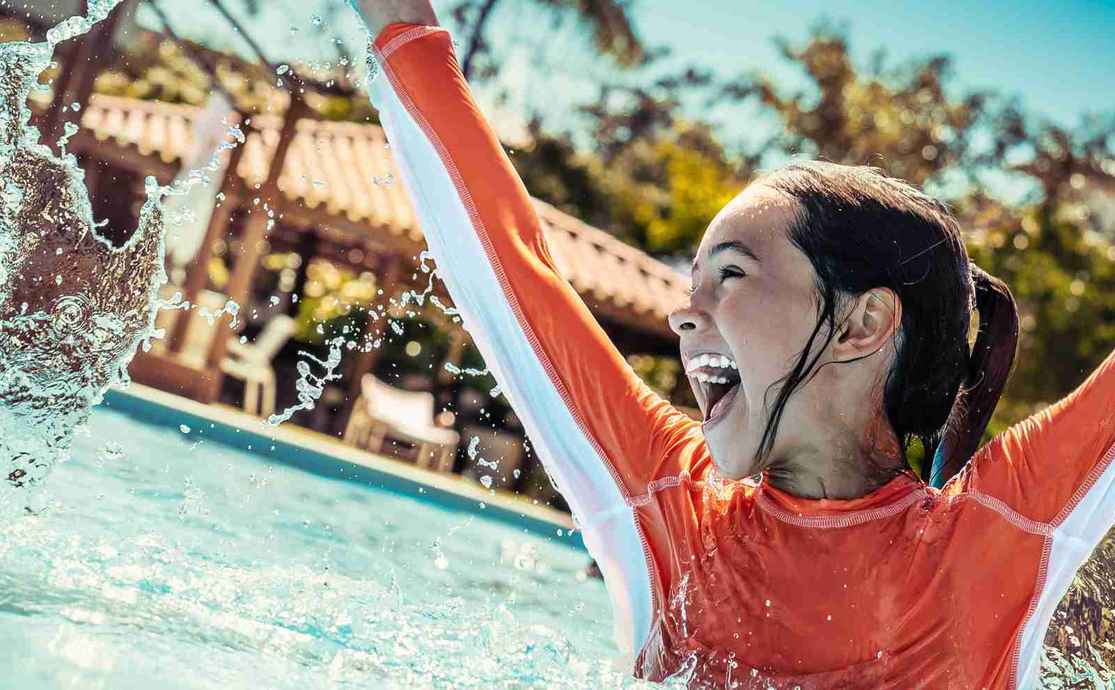 a girl splashing in a pool