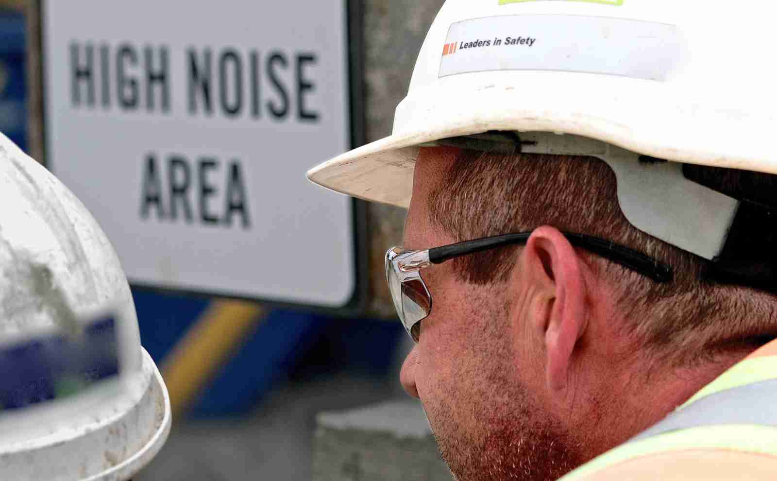 a man wearing a hard hat and sunglasses on a job site