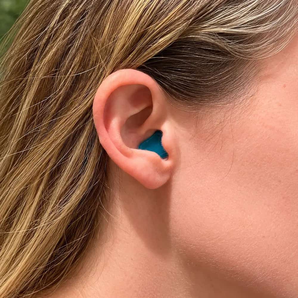 Teal earplug in a person's ear